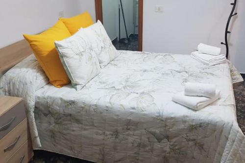 a bedroom with a bed with white sheets and yellow pillows at Vacacional Tegueste 2ºD in Vecindario
