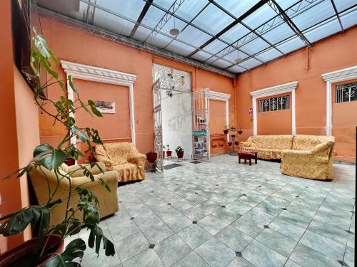 a living room with orange walls and couches at Casona Jerusalen in Arequipa
