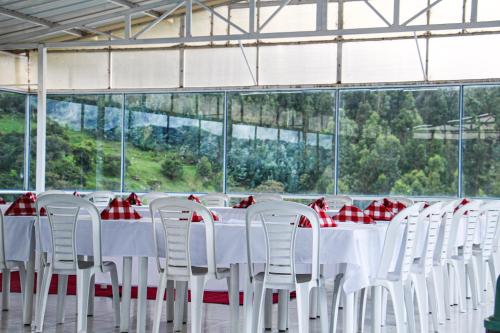 a group of tables and chairs with red and white tablecloths at Hotel Alta Montaña Mongui By Seres Viajeros in Tópaga