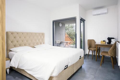 a bedroom with a large white bed and a table at Résidence la floraison in Brussels