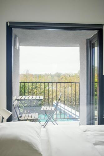 a bedroom with a balcony with a view of a pool at Résidence la floraison in Brussels