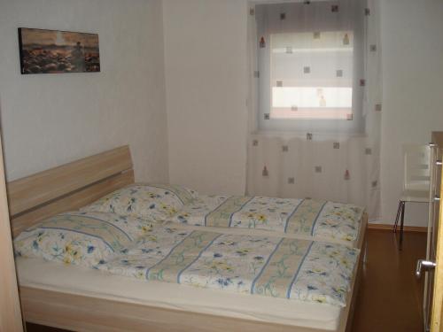 1 cama en un dormitorio con ventana en Haus Steinwaldblick, en Bernlohe