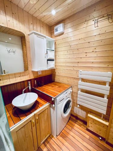 une salle de bain avec une machine à laver et un lavabo dans l'établissement MyHome - Le 44 ! Beau T2 plein centre Val Claret, skis aux pieds, 4 pax, à Tignes
