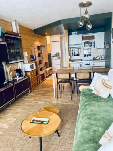 un salon avec un canapé et une table et une cuisine dans l'établissement MyHome - Le 44 ! Beau T2 plein centre Val Claret, skis aux pieds, 4 pax, à Tignes