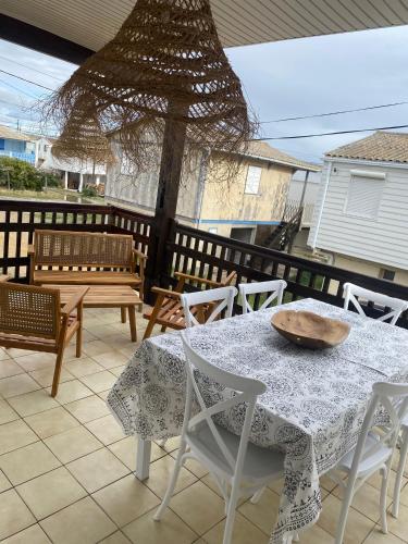 - une table et des chaises sur une terrasse avec une table et un bol dans l'établissement Chalet de plage, authentique !, à Gruissan