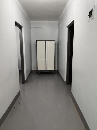 an empty hallway with white walls and two doors at Grand Square Hostel Luxor in Luxor