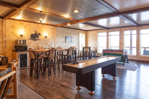 a room with tables and chairs and a pool table at Keweenaw Waters Resort in Houghton