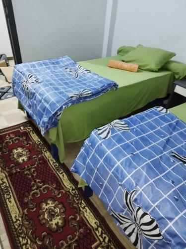 two beds sitting next to each other in a room at Grand Square Hostel Luxor in Luxor