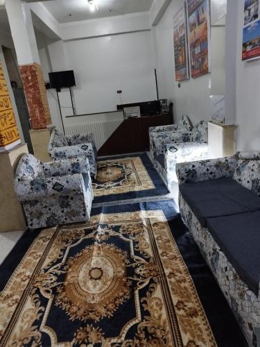 a living room with couches and a rug at Grand Square Hostel Luxor in Luxor