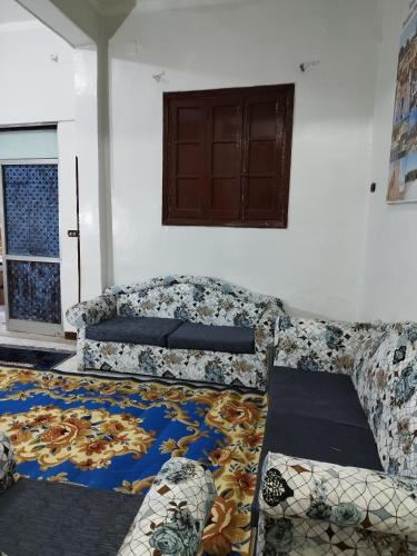 a living room with a couch and a window at Grand Square Hostel Luxor in Luxor