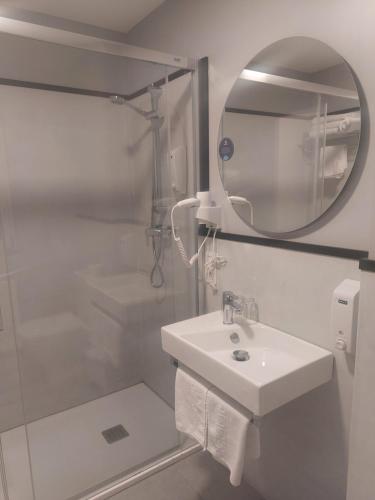 a white bathroom with a sink and a mirror at U-Hotel Darío Lugo in Lugo