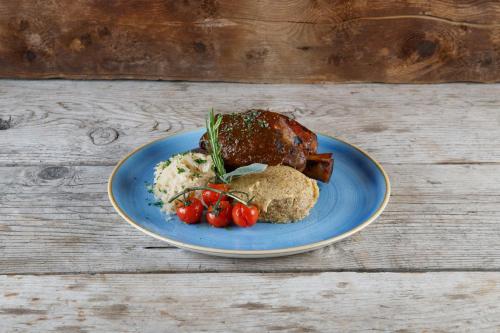 a blue plate with food on a wooden table at Rifugio Ghiacciaio dei Forni in Valfurva