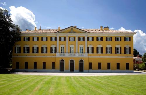 a large yellow house with a large yard at Parco Termale di Villa Dei Cedri in Lazise