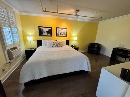 a bedroom with a large white bed with yellow walls at The Sherman Inn in Batesville