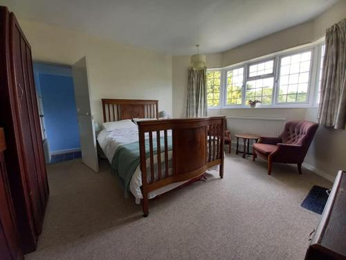a bedroom with a bed and a chair and window at Private 1-bedroom apartment in Raynes Park in Raynes Park