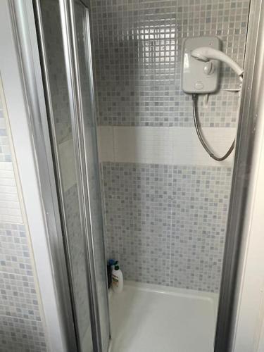 a shower with a glass door in a bathroom at Private 1-bedroom apartment in Raynes Park in Raynes Park