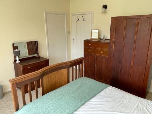 a bedroom with a crib and a dresser and a bed at Private 1-bedroom apartment in Raynes Park in Raynes Park