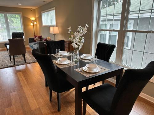 a dining room with a table and black chairs at Extended & Short Term Stays at The Oasis Group in Minneapolis