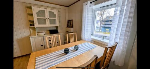 a dining room with a table and a window at Skagesundvegen 10a in Tromsø