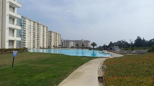 una piscina en un parque junto a un edificio en Departamento Laguna Bahía Algarrobo, en Algarrobo