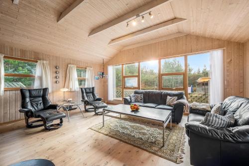 a living room with couches and chairs and a table at Cozy And Spacious Holiday Home Near Torup Strand Close To The North Sea in Fjerritslev