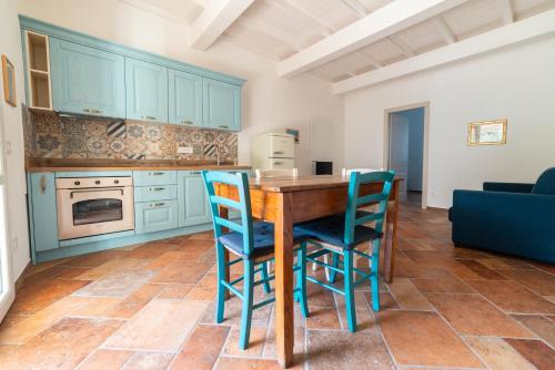 a kitchen with blue cabinets and a wooden table and chairs at Il Rosmarino in Marciana