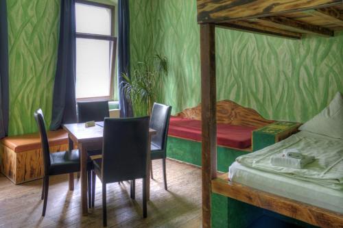 a room with a table and a bed and a table and chairs at Gästehaus Mezcalero in Dresden