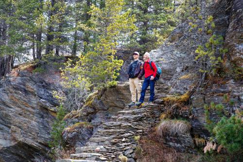 a man and woman walking on a rocky trail at Rifugio Ghiacciaio dei Forni in Valfurva