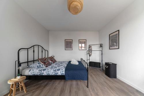 a bedroom with a black bed and a wooden floor at Résidence Léon Blum - Appartements design - Parking in Clermont-Ferrand