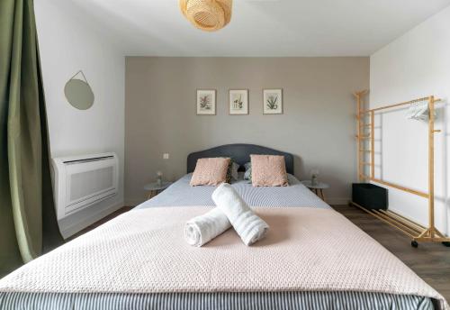 a bedroom with a bed with two towels on it at Résidence Léon Blum - Appartements design - Parking in Clermont-Ferrand