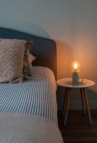 a bed with a table with a candle on it at Résidence Léon Blum - Appartements design - Parking in Clermont-Ferrand