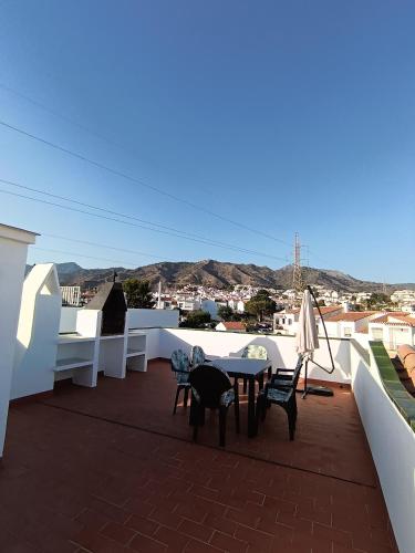 a patio with a table and chairs on a roof at La Casa de Gigi in Nerja