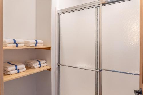 a glass shower door in a bathroom with towels at Keweenaw Waters Resort in Houghton