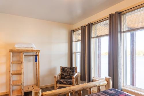 a room with windows and a chair and a bed at Keweenaw Waters Resort in Houghton