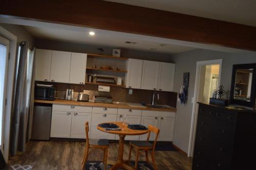 a kitchen with white cabinets and a table and chairs at Lake St Claire Waterfront, 1 beds, 1 bath in Olympia