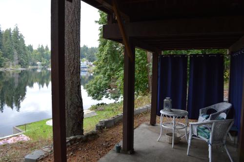 a patio with a table and chairs and a view of a lake at Lake St Claire Waterfront, 1 beds, 1 bath in Olympia