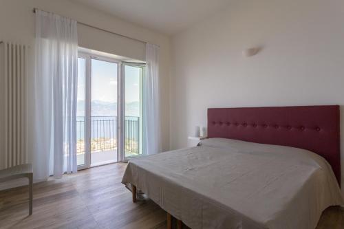 Villa Paola في توري ديل بيناكو: غرفة نوم بها سرير ونافذة كبيرة