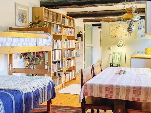 a room with a bed and a table and bookshelves at 4 person holiday home in HALLSTAVIK in Herräng