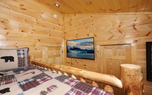 a bedroom with a bed in a log cabin at A Splash of Heaven in Pigeon Forge