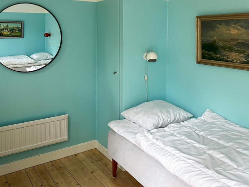 a blue room with a bed and a mirror at 6 person holiday home in SÖLVESBORG-By Traum in Sölvesborg