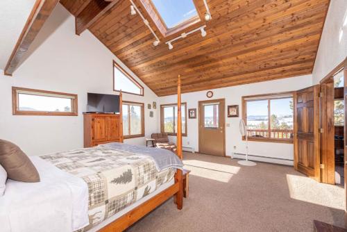 a bedroom with a large bed and a wooden ceiling at Take a break from it all escape to the mountains in Grand Lake
