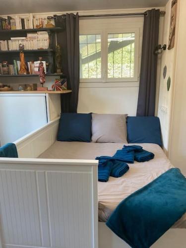 a bed in a room with blue pillows on it at L'échappée créative in Grenade-sur-Garonne