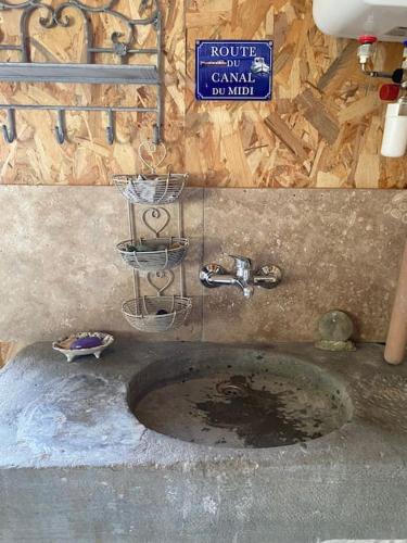 a dirty sink in a room with a sign at L'échappée créative in Grenade-sur-Garonne
