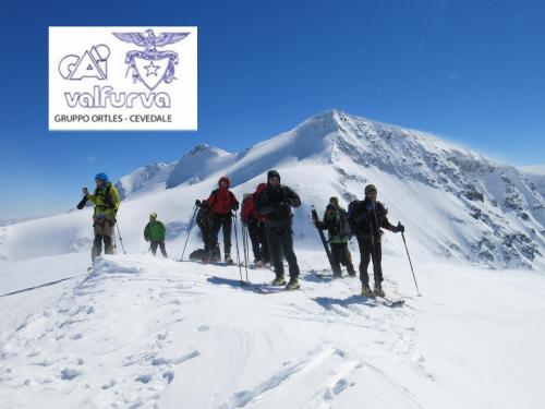 a group of people on skis in the snow at Rifugio Ghiacciaio dei Forni in Valfurva