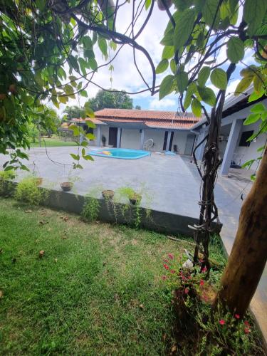 a house with a yard with a pool at Chácara Cantinho dos Sonhos in Chapada dos Guimarães