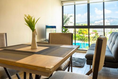 a dining room with a table with a vase on it at Cozy Apartment 2 Bedrooms Amenities in Acapulco