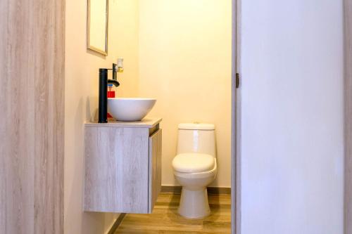 a bathroom with a white toilet and a sink at Cozy Apartment 2 Bedrooms Amenities in Acapulco