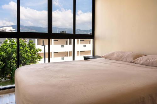 a bedroom with a bed and a large window at Cozy Apartment 2 Bedrooms Amenities in Acapulco