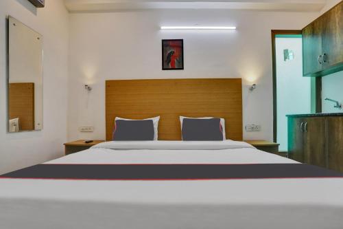 a bedroom with a large bed with a wooden headboard at Collection O The Miscue in Gurgaon