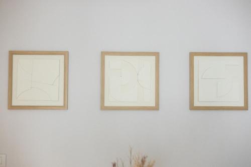 three picture frames on a white wall at Apartamento Ronda Muralla in Lugo